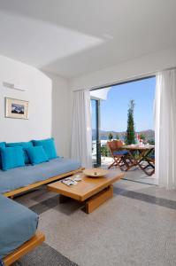 a living room with a blue couch and a table at Elounda Living Residences in Elounda