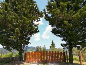 une clôture en bois avec deux arbres devant elle dans l'établissement Tenuta il Poggetto, à Radda in Chianti