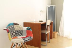 Un escritorio y una silla al lado de un escritorio con una lámpara. en A Casa da Ponte, en Ribeira Grande