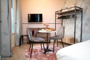 Cette chambre dispose d'une table, de chaises et d'une télévision. dans l'établissement The New Bliss - Duke Housing, à Vitry-sur-Seine