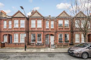 a brick building with a car parked in front of it at Spacious apartment near Hammersmith staion in London