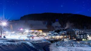 a resort in the snow at night at Aparthotel Czarna Perła - Czarna Góra Resort, Sun & Snow in Sienna