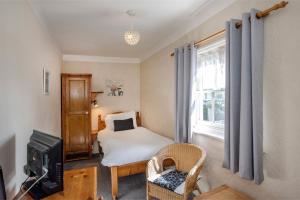 a bedroom with a bed and a tv and a window at Baldwin House in Stourport