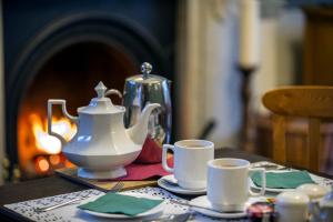 um bule de chá e duas chávenas numa mesa em Baldwin House em Stourport