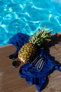 a pineapple in a blue shirt next to a swimming pool at MyseA VillasNikiti in Nikiti