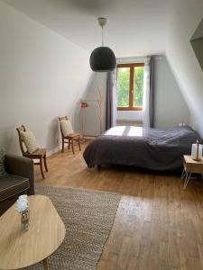 a bedroom with a bed and a couch and a table at Maison Vallée Vue avec piscine chauffée in Castelnaud La Chapelle +22 photos