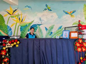 a man standing behind a table in front of a wall with birds at Gplace Hotel in Cebu City