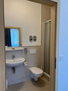a bathroom with a toilet and a sink at Avento Hotel Hannover in Hannover