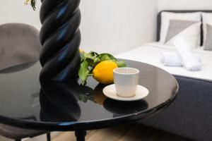 a table with a cup and two lemons on it at The Premium Stay - Duke Housing in Vitry-sur-Seine