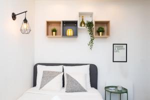 a bedroom with white walls and a bed with white pillows at The Premium Stay - Duke Housing in Vitry-sur-Seine