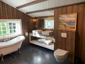 uma casa de banho com uma banheira, um lavatório e um WC. em Eventyrlig Tømmerhytte på Gårdstun em Vinstra