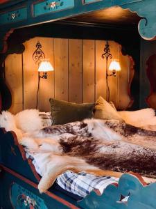 Una cama en una habitación con dos lámparas. en Eventyrlig Tømmerhytte på Gårdstun en Vinstra