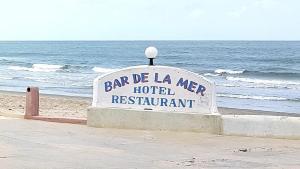 um sinal para um hotel na praia em HOTEL DU BAR DE LA MER CAP SKIRRiNG em Kabrousse