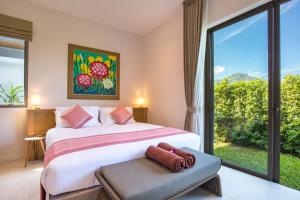 une chambre avec un lit et une grande fenêtre dans l'établissement Modern Eco Pool Villa Dalaa 7, à Kamala Beach