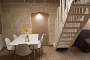a dining room with a white table and a staircase at Archetto Trentasei Casa Vacanze in Altamura