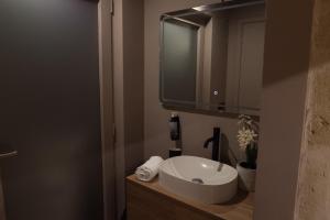 a bathroom with a white sink and a mirror at Archetto Trentasei Casa Vacanze in Altamura +1 photo