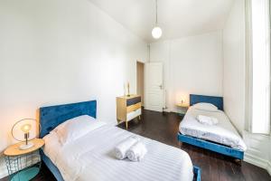 1 dormitorio con 2 camas y mesa con lámpara en Le Coty - en bord de Mayenne, en Laval