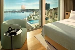 a hotel room with a bed and a large window at Hotel Ambasador in Split