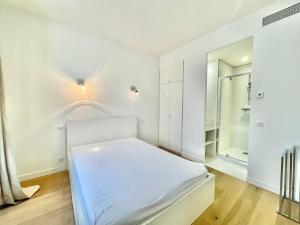 カンヌにあるJaurès Home by Welcome to Cannesの白いベッドルーム(ベッド1台、鏡付)