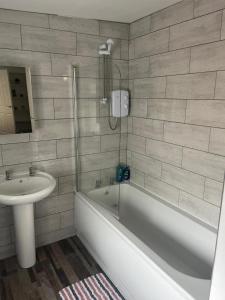 a bathroom with a tub and a sink and a shower at The Old Post Office Apartment in Adlington