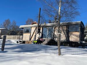 a person sitting on the porch of a house in the snow at VAGONBublava in Bublava