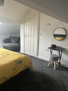 a bedroom with a bed and a table and a chair at The Old Post Office Apartment in Adlington