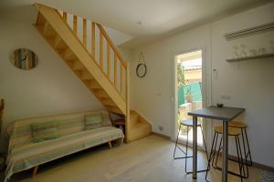 ein Wohnzimmer mit einem Sofa und einer Treppe in der Unterkunft Studio Le Prunelli PORTICCIO in Porticcio