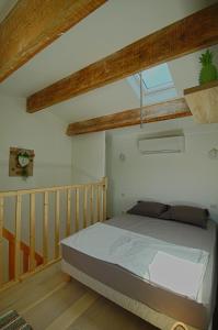 ein Schlafzimmer mit einem Bett in einem Zimmer mit Holzböden in der Unterkunft Studio Le Prunelli PORTICCIO in Porticcio