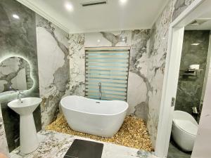 a bathroom with a white tub and a sink at Bao Ngoc hotel Pháp Vân in Hanoi +35 photos