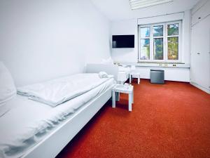 a bedroom with a white bed and a red carpet at CityChalet Business Apartments - Workers welcome! - Free Parking - Fast WIFI - Smart TV - WM in Saarbrücken