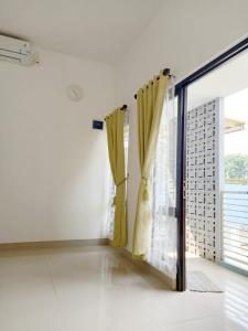 a room with a window with yellow curtains at Imah Safina, Cozy Private Home in Padalarang in Padalarang