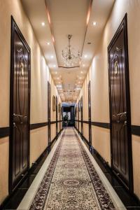 a corridor with doors and a carpeted hallway at ORIYO DUSHANBE HOTEL in Dushanbe