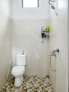 y baño blanco con aseo y ducha. en Imah Safina, Cozy Private Home in Padalarang en Padalarang