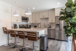 a kitchen with white cabinets and a island with bar stools at Redondo Beach 2br walk to shops restaurants LAX-1166 in Torrance
