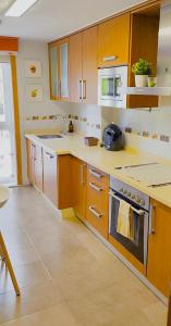 a kitchen with wooden cabinets and a stove top oven at Apartamento Buen Camino in O Pedrouzo