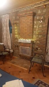 a living room with a stone wall with a fireplace at Dabakhnebi in Telavi