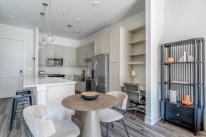 a kitchen and dining room with a table and chairs at Highlands 1br w pool wd gym vibrant area ATX-201 in Austin