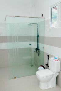 a bathroom with a glass shower with a toilet at DK Zur Einkehr Hotel in Ahangama