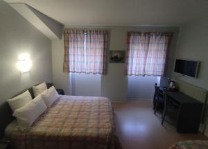 sypialnia z łóżkiem i biurkiem w pokoju w obiekcie Central Hôtel w mieście Cerbère