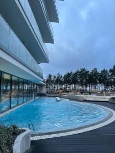 a swimming pool in front of a building at WAVE 10th Floor Baltic View in Międzyzdroje