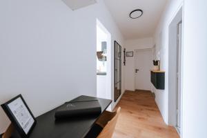 a dining room with a black table and a hallway at Apartman Vista in Daruvar
