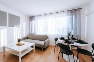 a living room with a couch and a table and chairs at Apartman Vista in Daruvar