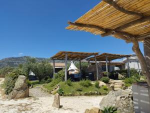 a view of a garden with a wooden roof at Cuccuru Relax - A IUN Q9882 in Orosei
