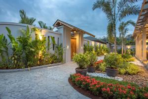 een huis met een binnenplaats met bloemen en planten bij Dalaa 8 in Kamala Beach