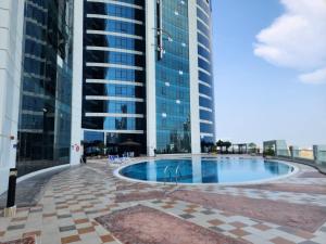a swimming pool in the middle of a building at Comfy Studio with Stunning Vista, Pool and Gym in Abu Dhabi
