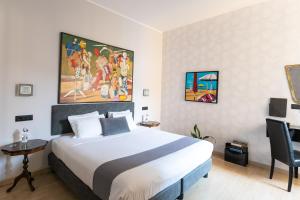a hotel room with a bed and a painting on the wall at Aiello Rooms in Milan