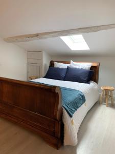 1 dormitorio con cama de madera y almohadas azules en Maison de famille 24 en Trélissac