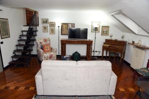 ein Wohnzimmer mit einem weißen Sofa und einem TV in der Unterkunft Appartamento Viale Corsica 99 in Mailand