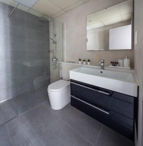 a bathroom with a sink and a toilet and a mirror at Frank Porter - Marina Quays in Dubai