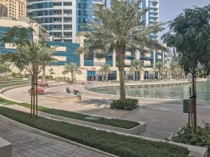 a park with palm trees in front of buildings at Frank Porter - Marina Quays in Dubai